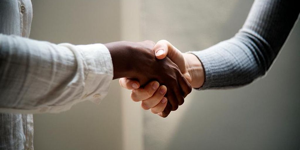 business partners shaking hands in an office setting
