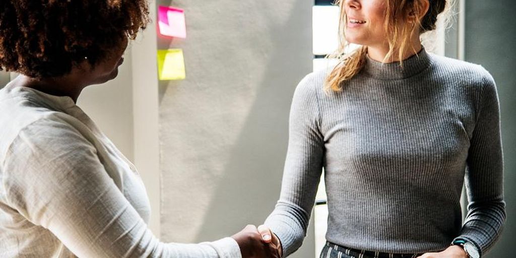 business partners shaking hands in an office setting